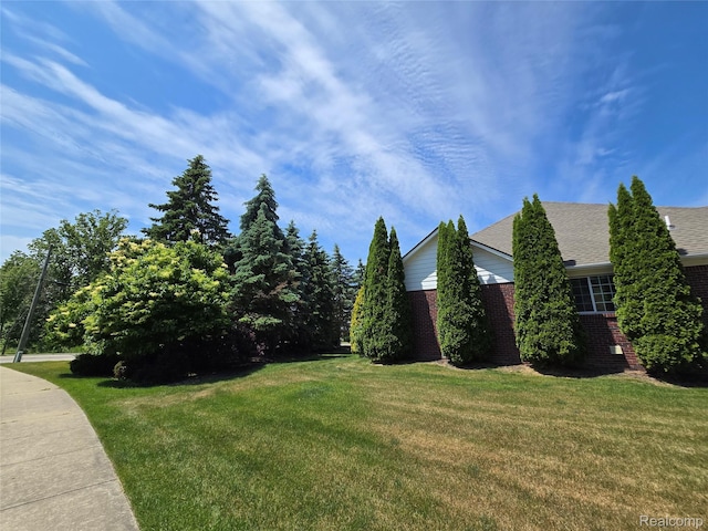 35260 Bradford Dr, New Baltimore, MI 48047 - view of side of home with brick siding, a lawn, and roof with shingles