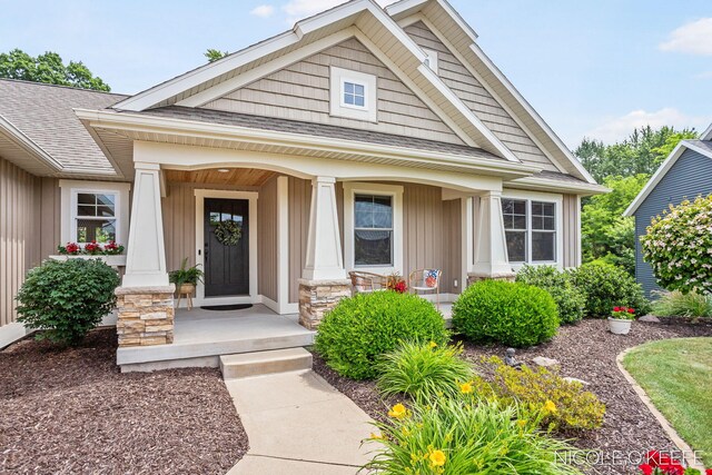7150 Limerick Ln SW, Byron Center, MI 49315 - view of front facade featuring board and batten siding, roof with shingles, covered porch, and stone siding