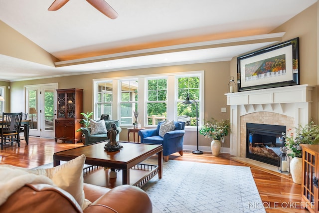7150 Limerick Ln SW, Byron Center, MI 49315 - living area featuring a tiled fireplace, wood finished floors, a ceiling fan, and ornamental molding