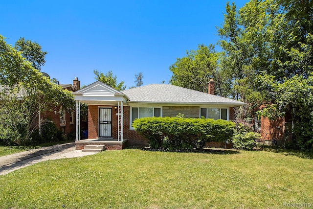 20515 Strathmoor St, Highland Park, MI 48235 - view of front of house with a chimney, a front yard, and brick siding