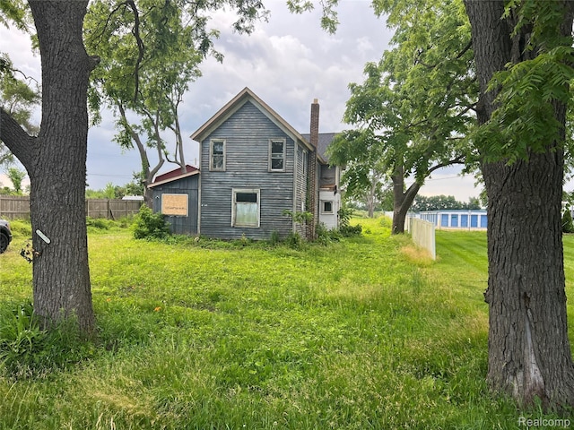 6737 Oak Grove Rd, Howell, MI 48855 - rear view of property featuring a chimney