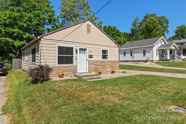 1035 Eastern Ave NE, Grand Rapids, MI 49503 - bungalow-style home featuring stone siding, a front yard, and board and batten siding