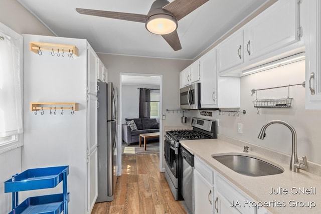 1035 Eastern Ave NE, Grand Rapids, MI 49503 - kitchen with appliances with stainless steel finishes, light wood finished floors, white cabinets, and light countertops