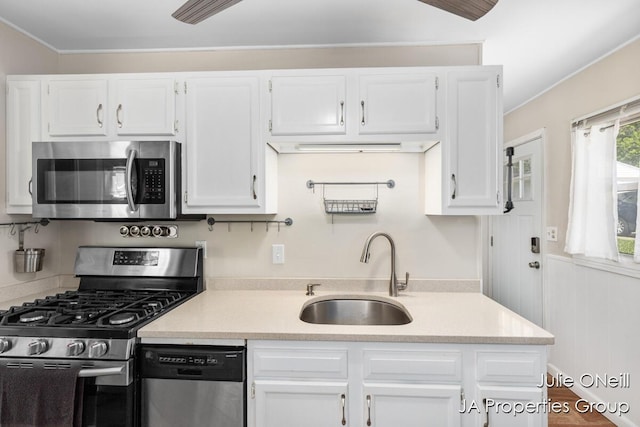 1035 Eastern Ave NE, Grand Rapids, MI 49503 - kitchen with appliances with stainless steel finishes, light countertops, white cabinetry, crown molding, and wood finished floors