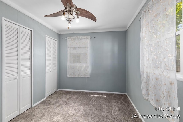 1035 Eastern Ave NE, Grand Rapids, MI 49503 - unfurnished bedroom with carpet, multiple closets, ornamental molding, and a ceiling fan