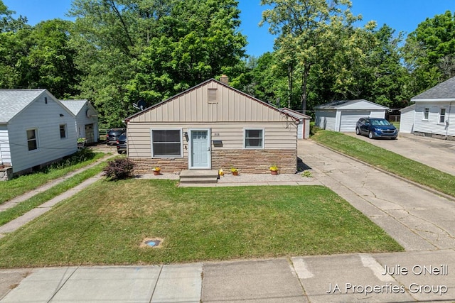 1035 Eastern Ave NE, Grand Rapids, MI 49503 - bungalow-style house featuring stone siding, a front lawn, board and batten siding, and an outbuilding
