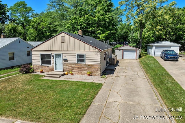 1035 Eastern Ave NE, Grand Rapids, MI 49503 - bungalow featuring stone siding, a detached garage, a front yard, driveway, and a chimney