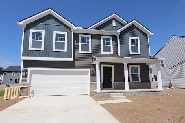 54695 Heron Cir, New Baltimore, MI 48047 - view of front of home featuring covered porch, a garage, concrete driveway, and board and batten siding