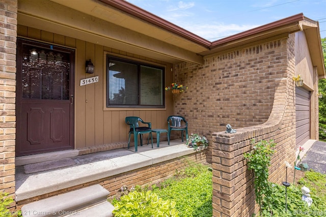 31450 Orchard Brook Ct Unit 8, Farmington Hills, MI 48336 - view of exterior entry with brick siding, covered porch, and an attached garage