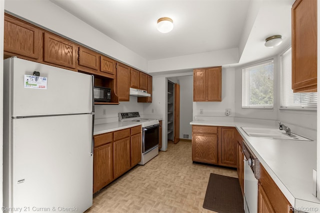 31450 Orchard Brook Ct Unit 8, Farmington Hills, MI 48336 - kitchen featuring white appliances, under cabinet range hood, brown cabinetry, and light countertops