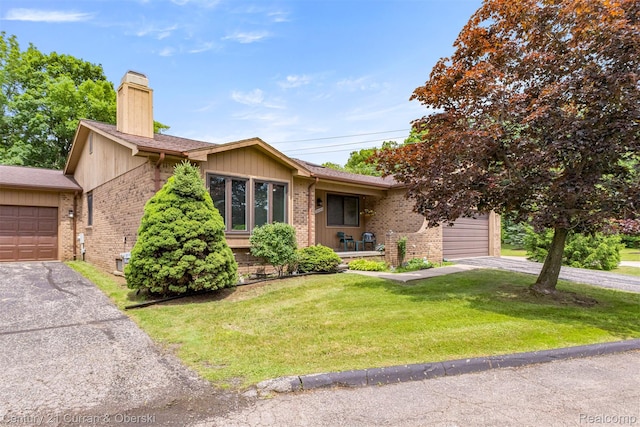 31450 Orchard Brook Ct Unit 8, Farmington Hills, MI 48336 - view of front of house featuring brick siding, a chimney, a front lawn, and an attached garage