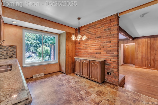 1840 Glen Iris Dr, Commerce Twp, MI 48382 - unfurnished dining area featuring wood walls and a chandelier
