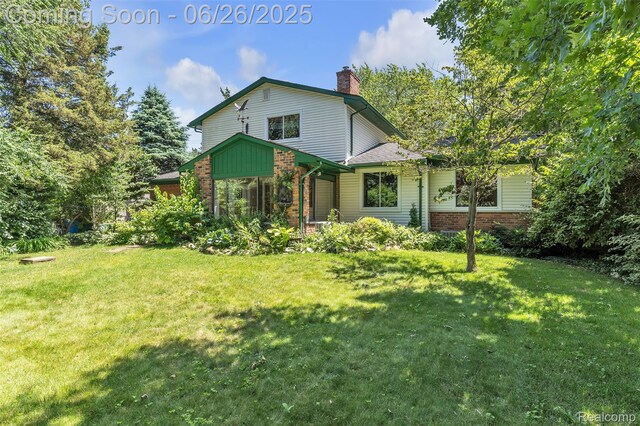 1840 Glen Iris Dr, Commerce Twp, MI 48382 - view of front of home featuring brick siding, a front yard, and a chimney