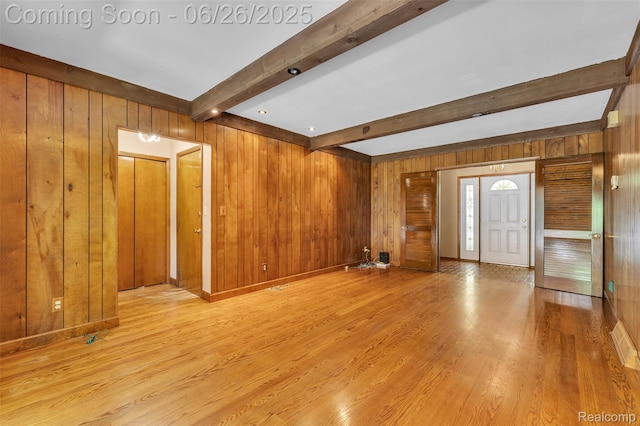 1840 Glen Iris Dr, Commerce Twp, MI 48382 - unfurnished living room with wood walls, beamed ceiling, and light wood-style flooring