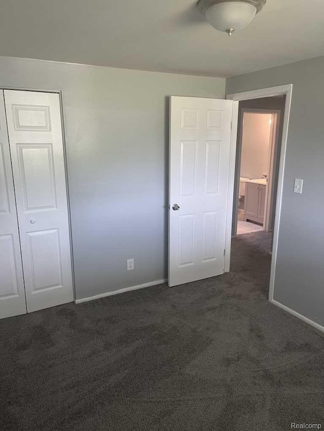 2162 W Coldwater Rd, Flint, MI 48505 - unfurnished bedroom with dark colored carpet and baseboards