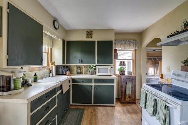 2030 W Sterns Rd, Temperance, MI 48182 - kitchen featuring white appliances, light wood finished floors, light countertops, decorative backsplash, and under cabinet range hood