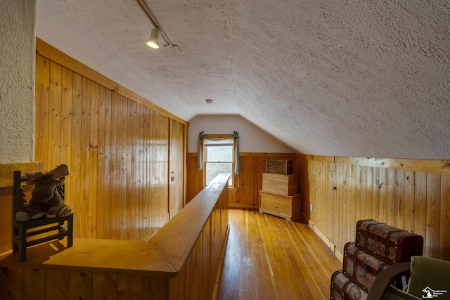 2030 W Sterns Rd, Temperance, MI 48182 - hall featuring wooden walls, a textured ceiling, hardwood / wood-style floors, and lofted ceiling