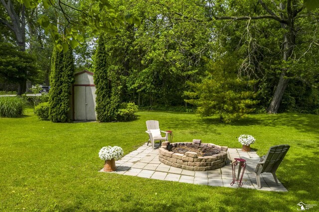 2030 W Sterns Rd, Temperance, MI 48182 - view of green lawn featuring an outdoor fire pit, a storage shed, and a patio