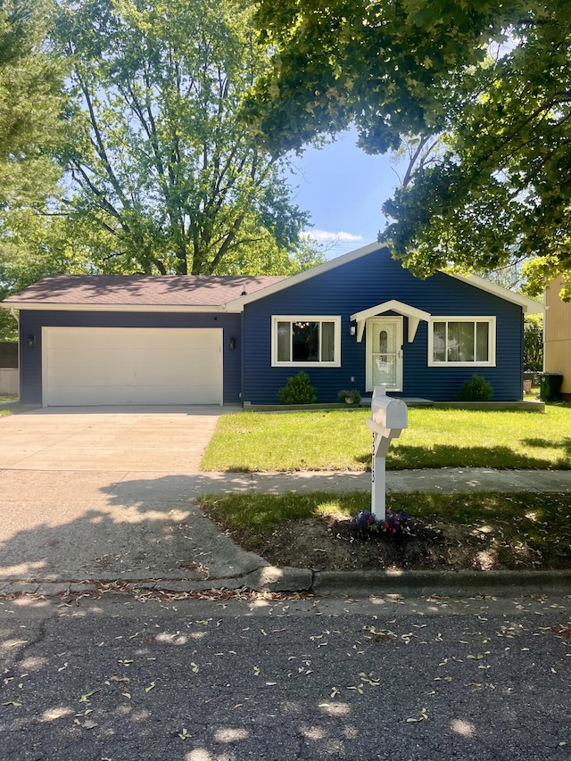 5213 Crocus Ave, Lansing, MI 48911 - view of front of house featuring a garage, concrete driveway, and a front lawn