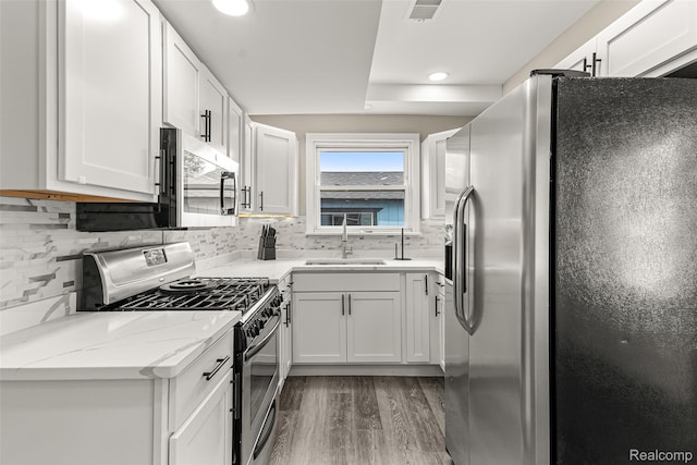 8329 Lenore St, Dearborn Heights, MI 48127 - kitchen with stainless steel appliances, light wood-style flooring, tasteful backsplash, light stone counters, and recessed lighting