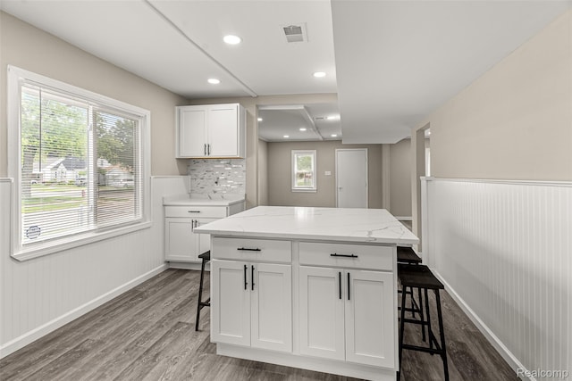 8329 Lenore St, Dearborn Heights, MI 48127 - kitchen featuring a breakfast bar, wood finished floors, white cabinetry, wainscoting, and light stone countertops