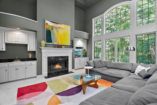 4608 Old Grand River Trl NE, Ada, MI 49301 - living room featuring a towering ceiling, a premium fireplace, wet bar, and light carpet