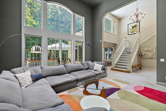 4608 Old Grand River Trl NE, Ada, MI 49301 - carpeted living room featuring a high ceiling, stairs, and a chandelier