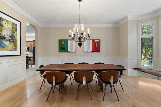 4608 Old Grand River Trl NE, Ada, MI 49301 - dining space with arched walkways, light wood-style floors, a chandelier, a wainscoted wall, and ornamental molding