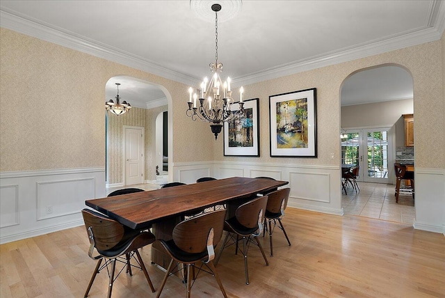 4608 Old Grand River Trl NE, Ada, MI 49301 - dining room with arched walkways, a chandelier, light wood-style flooring, crown molding, and a wainscoted wall
