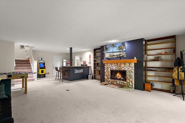 4608 Old Grand River Trl NE, Ada, MI 49301 - carpeted living area featuring stairs, a dry bar, and a stone fireplace