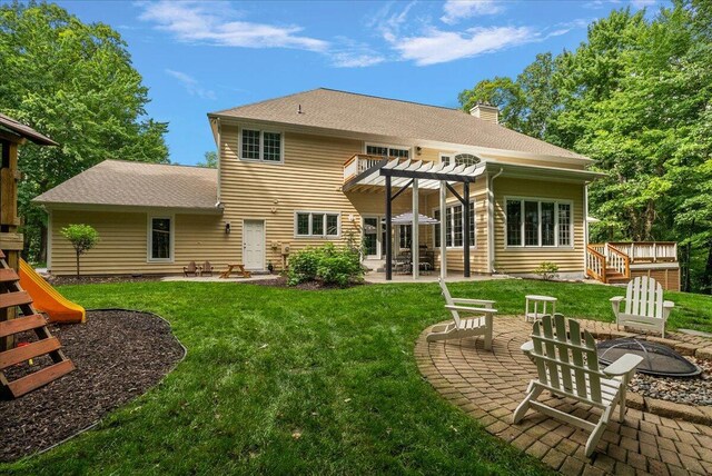 4608 Old Grand River Trl NE, Ada, MI 49301 - rear view of house with a fire pit, a pergola, a chimney, a patio, and a yard