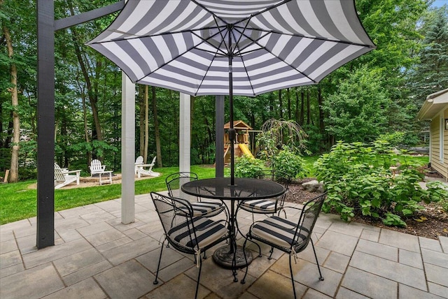 4608 Old Grand River Trl NE, Ada, MI 49301 - view of patio / terrace with a playground, outdoor dining space, and an outdoor fire pit