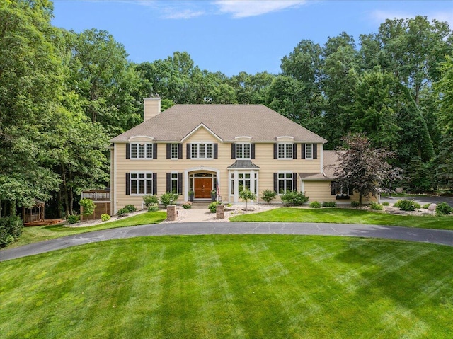 4608 Old Grand River Trl NE, Ada, MI 49301 - colonial house featuring a front lawn and a chimney