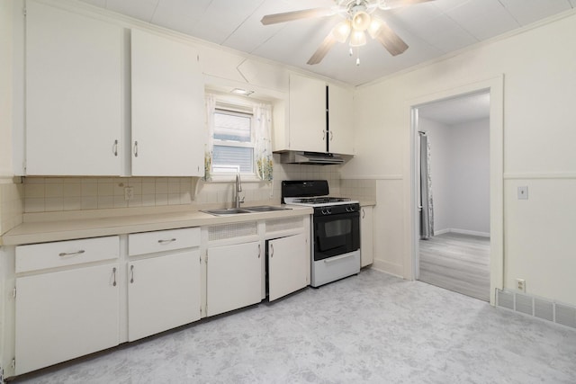 3415 Hoover St, Kalamazoo, MI 49008 - kitchen with white range with gas stovetop, under cabinet range hood, a ceiling fan, tasteful backsplash, and light countertops