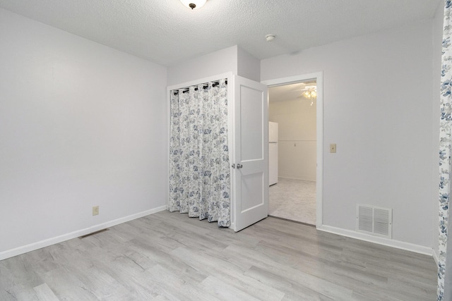 3415 Hoover St, Kalamazoo, MI 49008 - unfurnished bedroom with light wood finished floors, a textured ceiling, and freestanding refrigerator