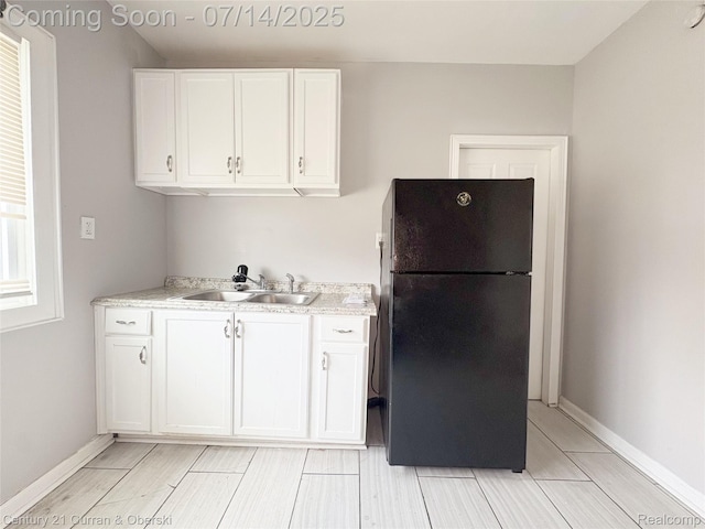 2135 Lakewood, Detroit, MI 48215 - kitchen with freestanding refrigerator, white cabinetry, light countertops, and wood tiled floors