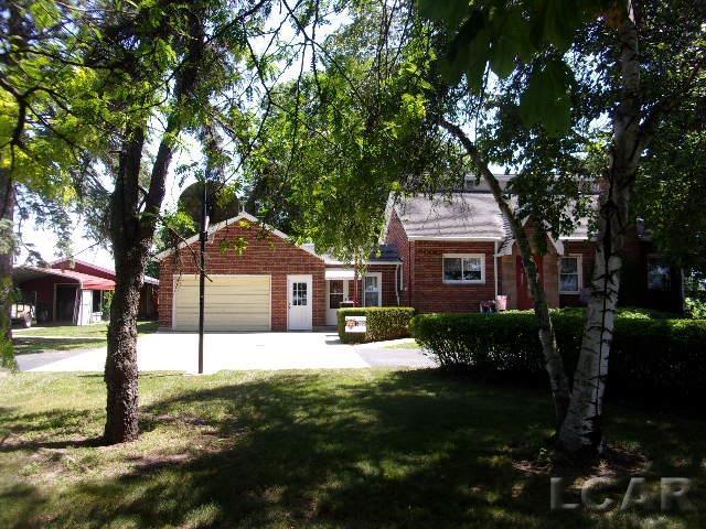 9981 W Mulberry Rd, Morenci, MI 49256 - view of front of house featuring a garage, a front lawn, and concrete driveway