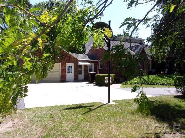 9981 W Mulberry Rd, Morenci, MI 49256 - back of property featuring brick siding, a garage, and a yard