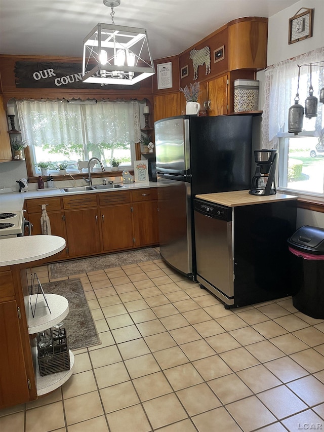 9981 W Mulberry Rd, Morenci, MI 49256 - kitchen featuring stainless steel appliances, light countertops, brown cabinetry, open shelves, and hanging light fixtures