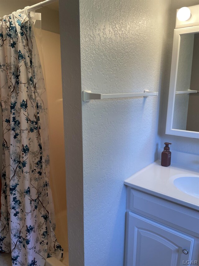 9981 W Mulberry Rd, Morenci, MI 49256 - full bath featuring vanity, shower / bath combo with shower curtain, and a textured wall
