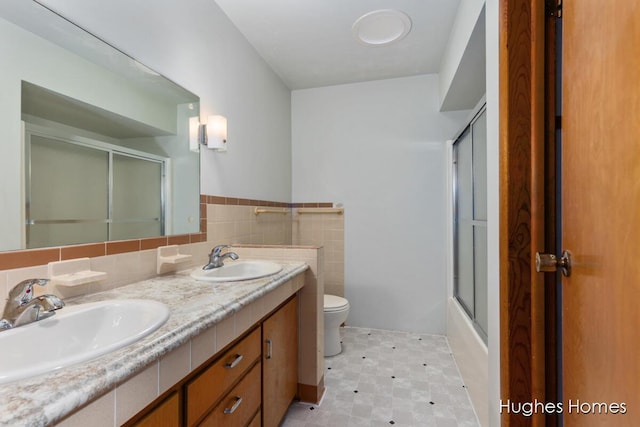 7970 Burlingame Ave SW, Byron Center, MI 49315 - full bathroom with double vanity, tile walls, tile patterned floors, and a wainscoted wall