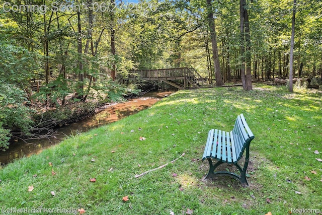 30715 River Crossing St, Bingham Farms, MI 48025 - view of grassy yard featuring stairway, a wooden deck, and a wooded view