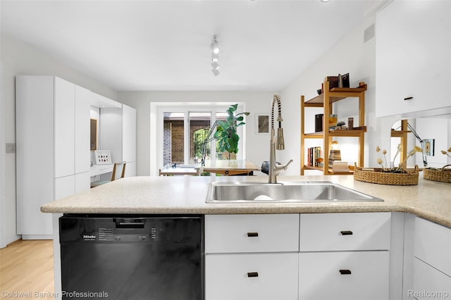 30715 River Crossing St, Bingham Farms, MI 48025 - kitchen with dishwashing machine, light countertops, white cabinetry, light wood finished floors, and rail lighting