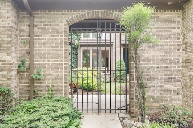 30715 River Crossing St, Bingham Farms, MI 48025 - view of exterior entry with brick siding and a gate