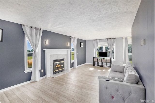 11632 Glen Mary Dr, Byron, MI 48418 - living area featuring wood finished floors, a tile fireplace, and a textured ceiling