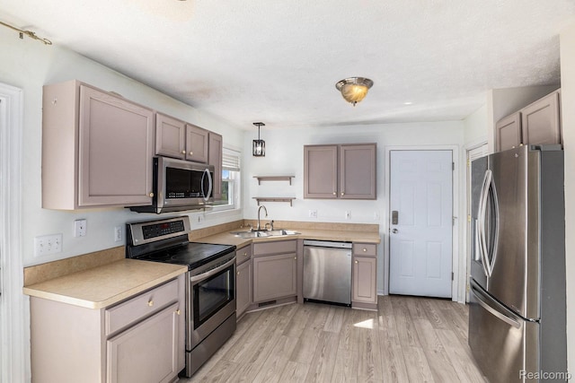 11632 Glen Mary Dr, Byron, MI 48418 - kitchen with appliances with stainless steel finishes, light wood-type flooring, light countertops, and decorative light fixtures