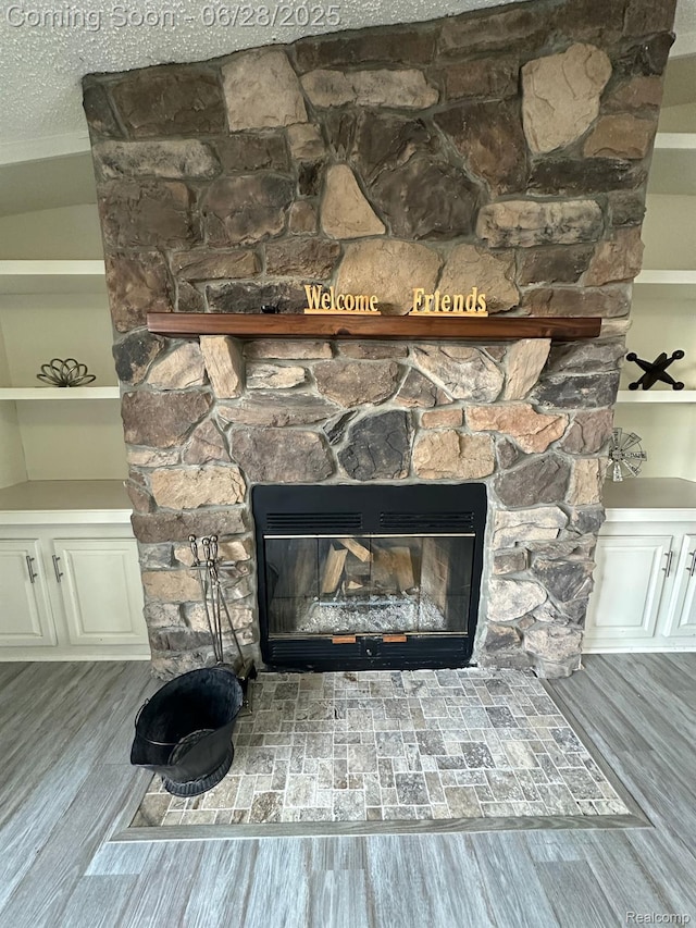 2652 Murphy Lake Rd, Silverwood, MI 48760 - detailed view of a stone fireplace, wood finished floors, and a textured ceiling