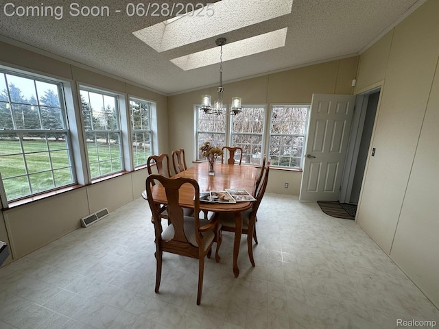 2652 Murphy Lake Rd, Silverwood, MI 48760 - dining area featuring a skylight, a chandelier, lofted ceiling, light flooring, and a textured ceiling