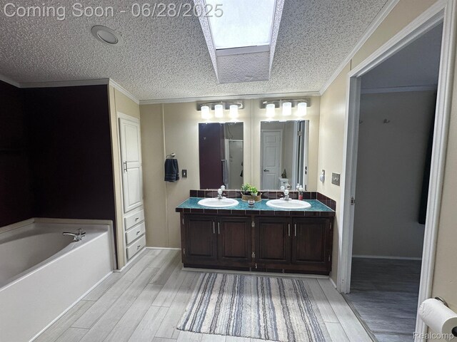 2652 Murphy Lake Rd, Silverwood, MI 48760 - bathroom with a skylight, wood finished floors, double vanity, a garden tub, and ornamental molding