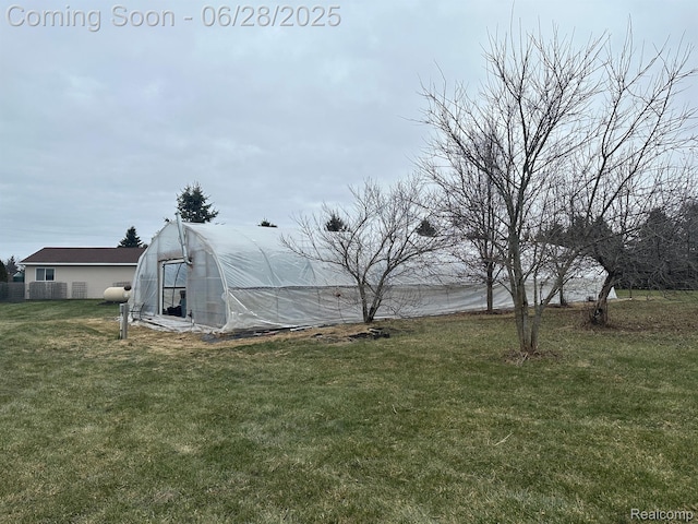 2652 Murphy Lake Rd, Silverwood, MI 48760 - view of grassy yard featuring a greenhouse and an outbuilding